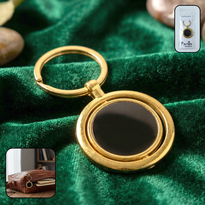 Gold plated keychain with black round rotating pendant, stylish keyring accessory.