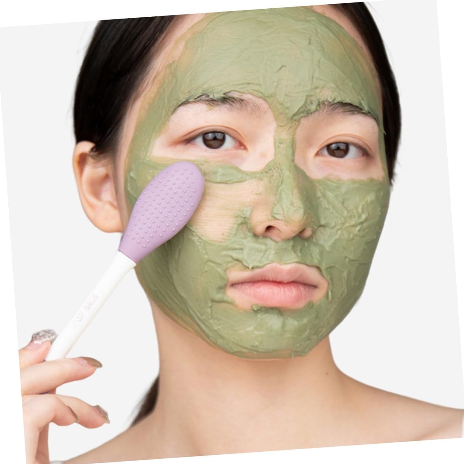 The silicone mask applicator brush displayed with a tube of face mask product.