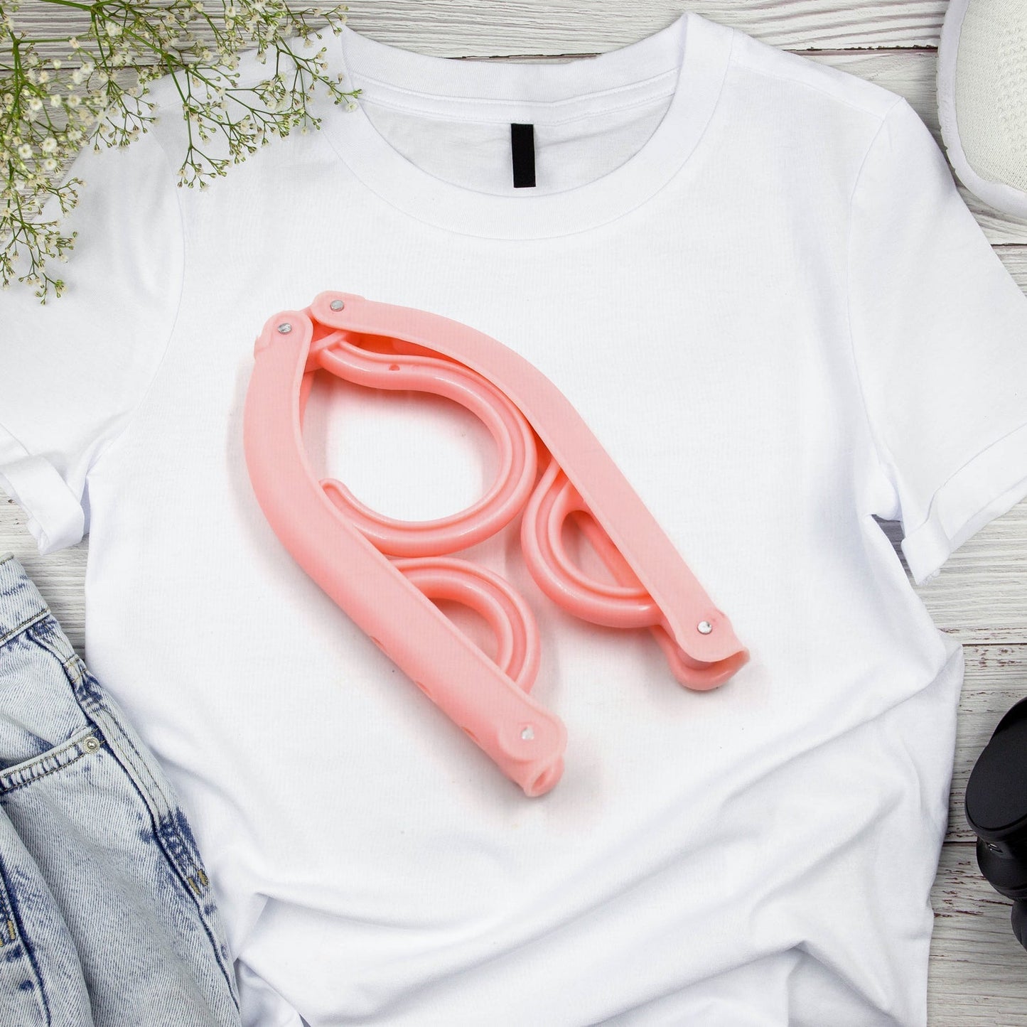 Set of portable folding clothes hangers for travel, neatly holding shirts and trousers.