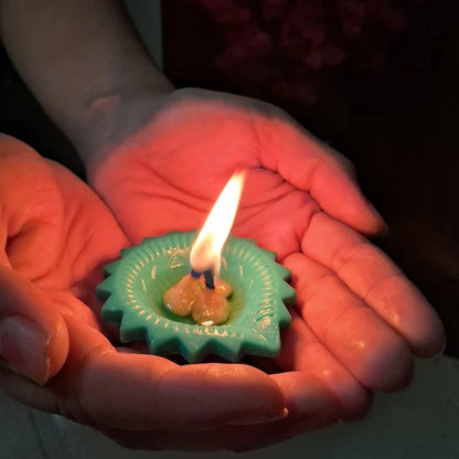 A single lit silicone diya glowing warmly on a dark surface, enhancing its festive appeal.
