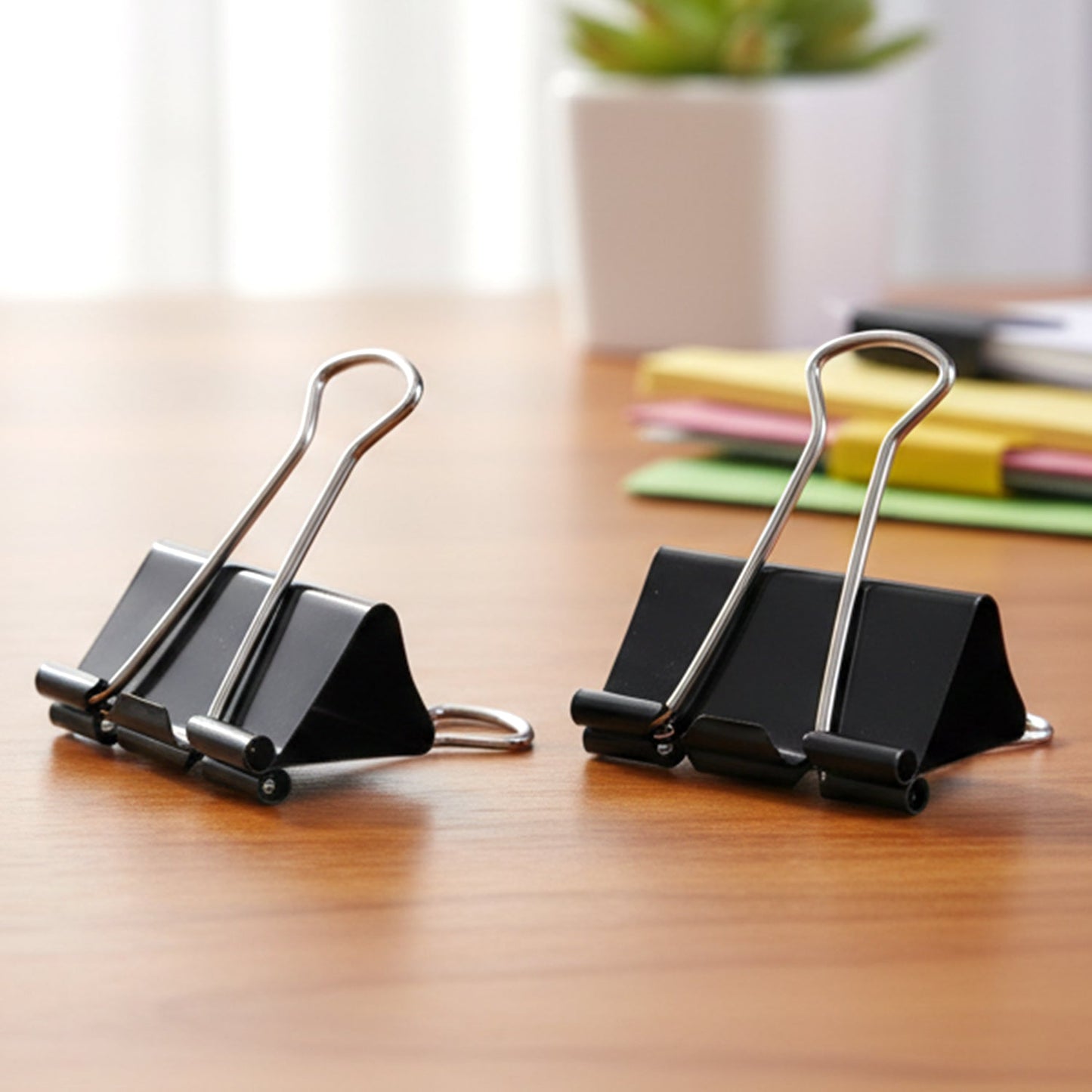 Close-up of 12 black metal binder clips in a set