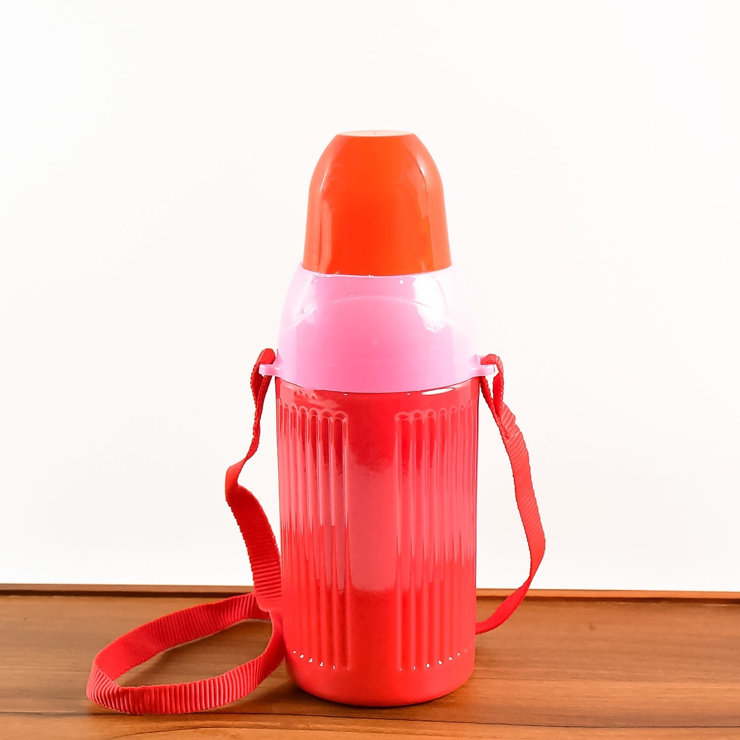 The insulated water bottle with its lid open, revealing the internal drinking straw.