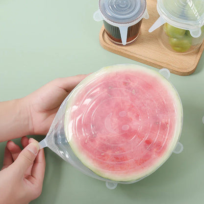An overhead shot of different sizes of silicone food covers displayed on a clean kitchen counter.