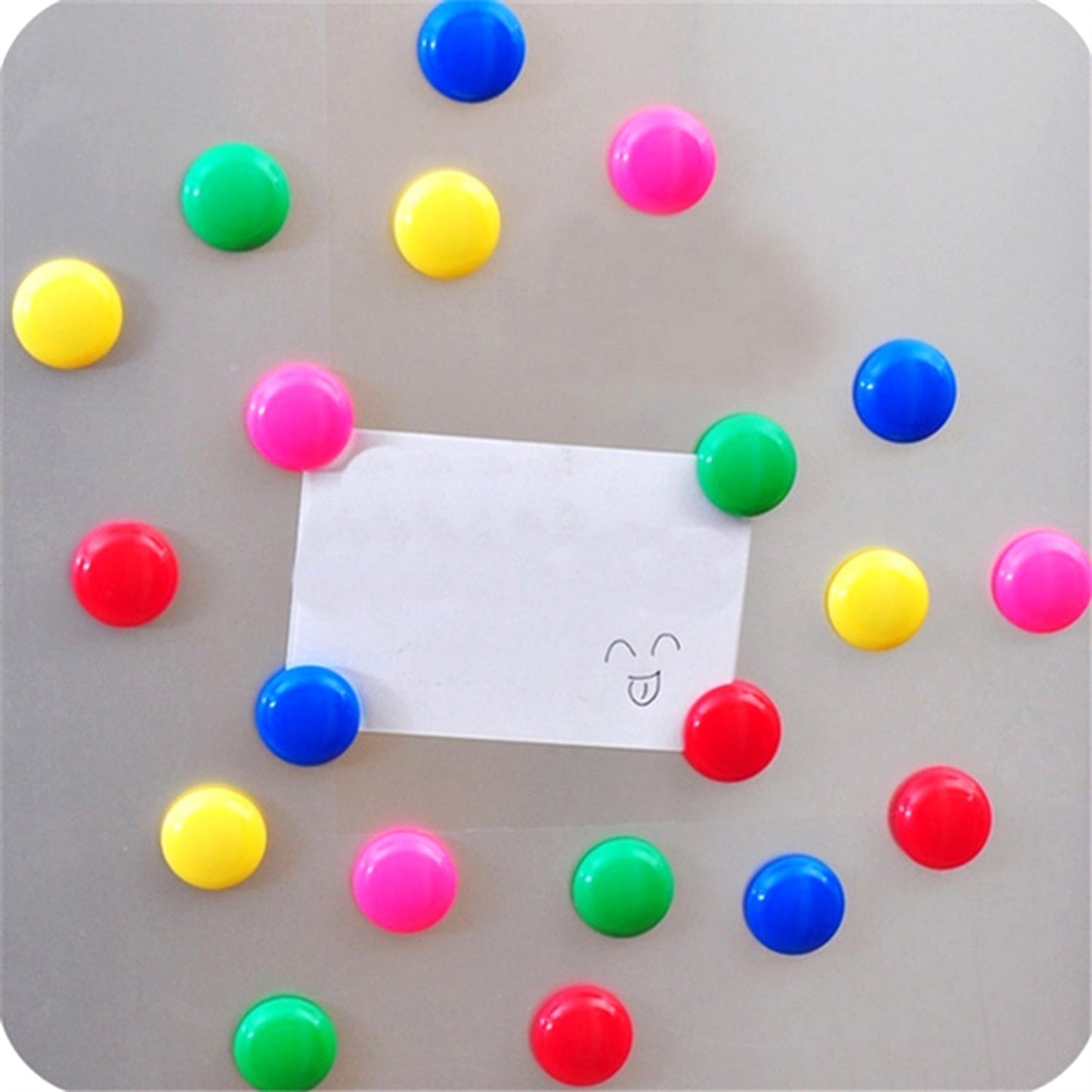 Colorful magnetic pins holding papers on a whiteboard in an office setting.