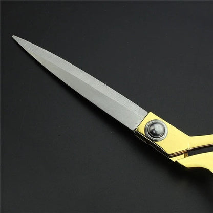 Ergonomic golden handle detail of the professional fabric cutting scissors.