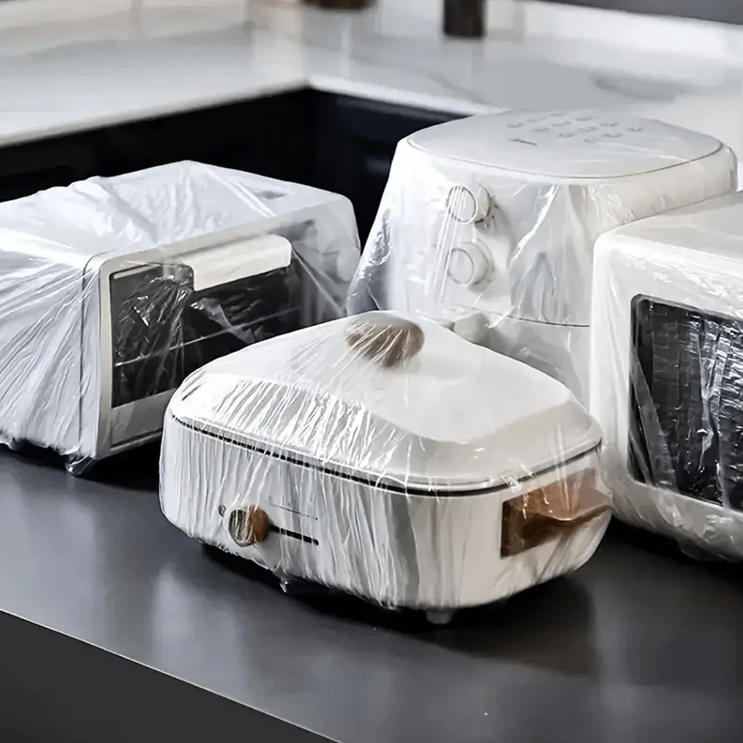 Multiple transparent disposable plastic furniture covers stacked neatly.