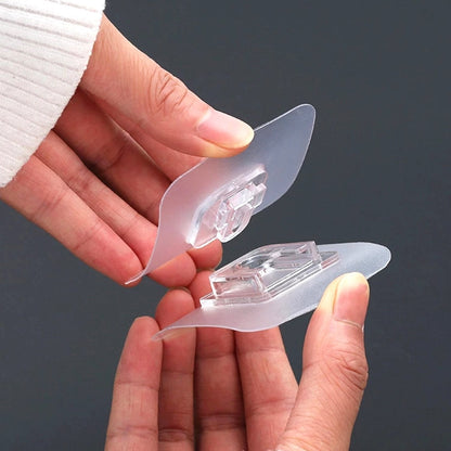 A clear adhesive wall hook holding a heavy coat, showcasing its 13 lbs weight capacity.