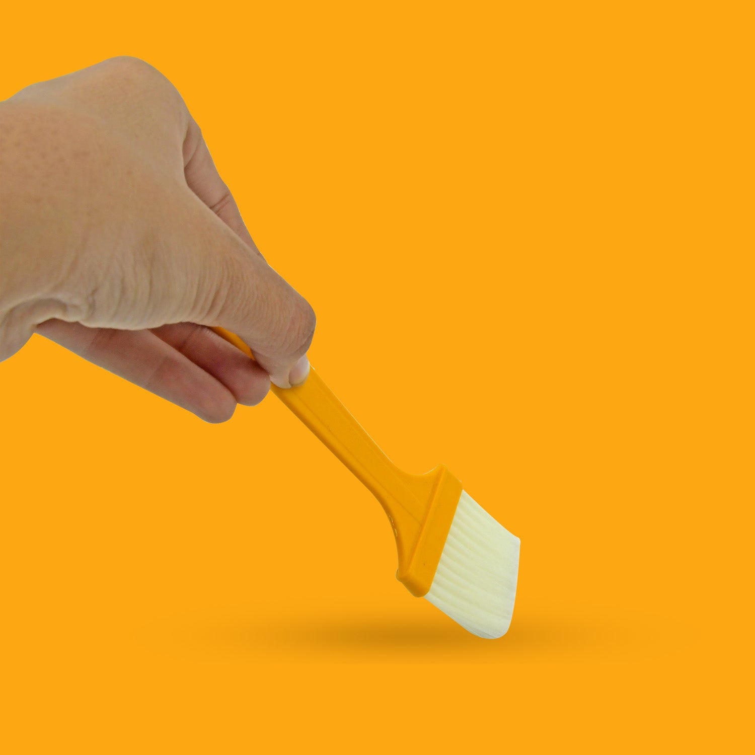 Dishwasher safe silicone brush resting on a kitchen countertop.