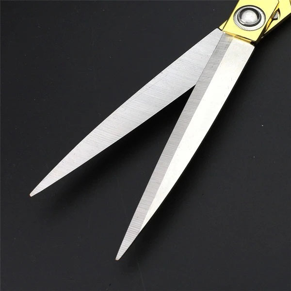 Professional golden tailoring scissors angled on a cutting mat, highlighting their sleek design.