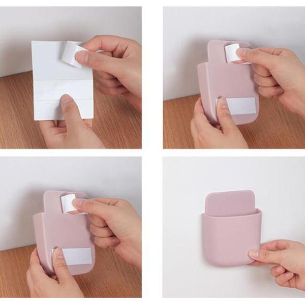 A smartphone securely held in a wall mounted phone holder with a charging cable neatly routed.