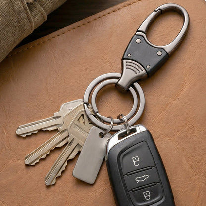 Hand holding compact metal key holder with rotating swivel